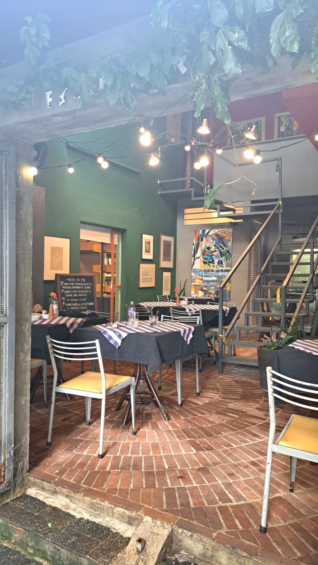 Salão interno com mesas e obras de arte